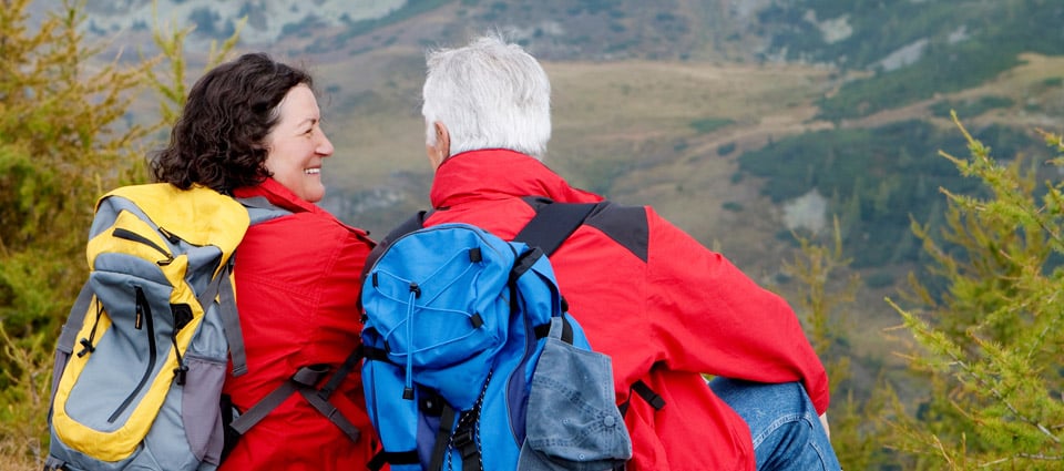 man and woman smiling on a hike